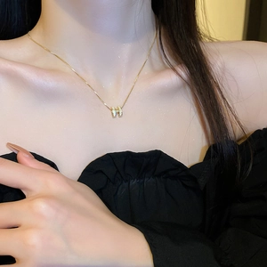 Elegant gold-plated H-shaped pendant necklace with white enamel details for women