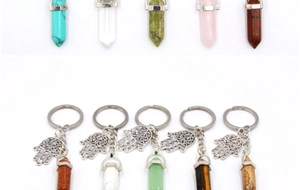 Detailed view of hex crystal keychains with Hamsa Hand charms in various natural gemstones