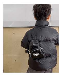 Close-up of a black leather kids chest bag featuring white Cute letter print detail