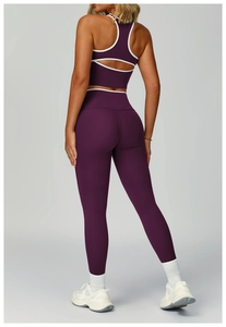 Dettaglio del set yoga prugna con reggiseno sportivo aperto dietro e leggings con bordi bianchi