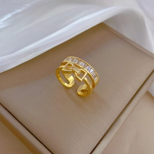 Golden bow-knot open ring with double-layered cubic zirconia on a luxury silk background