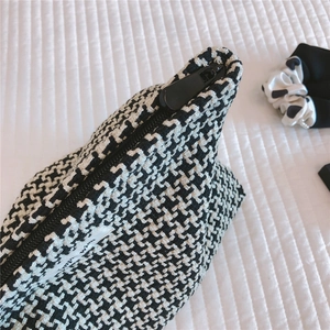 Macro shot of houndstooth weave fabric with black zipper and branded fabric label