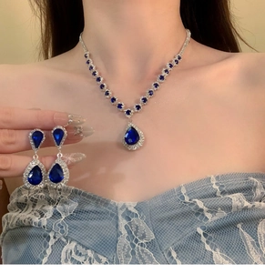 Detail of luxury teardrop zircon necklace and earrings set worn by a model