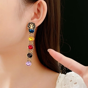 Vue détaillée des boucles d'oreilles tête de lion vintage avec pierres de couleur et glands