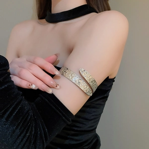 Detailed view of silver arm cuff with vintage floral relief on adjustable metal band
