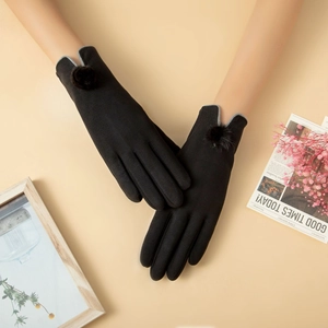 Detalle de guantes térmicos negros con ribete de piel sintética gris y pompones decorativos