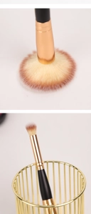 Détail du pinceau de maquillage à double embout avec poils doux et tube en métal doré