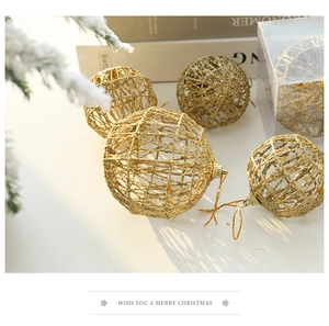 Detailed view of hollow gold iron Christmas balls with pine branches on a white surface