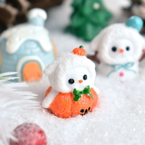 Macro shot of a flocked resin animal in a pumpkin base with festive winter snow scene