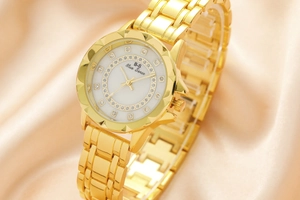 Detailed close-up of a luxury gold women's watch with crystal-encrusted floral dial and chain