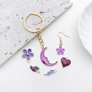 Golden DIY keychain set with purple oil drip moon and heart pendants for jewelry making