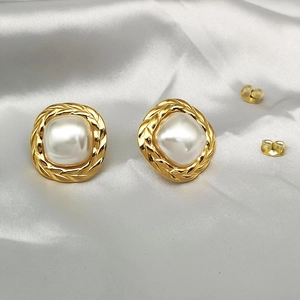 Detail view of gold-plated twisted rope bezel around the white pearl on vintage earrings