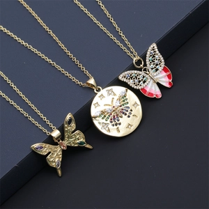 Detailed view of three gold butterfly necklaces with rhinestones and evil eye enamel