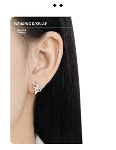 Close-up display of a minimalist polished S925 sterling silver bow earring on a model