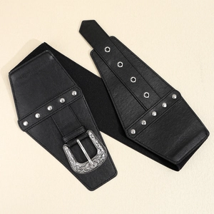 Detail of black elastic wide belt featuring vintage silver engraved buckle and metal studs
