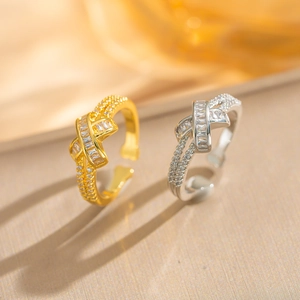 Detail von X-förmigen Ringen mit Zirkonia-Besatz in Gold und Silber Ausführung