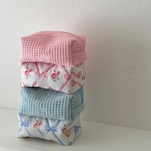 Floral and waffle pattern cosmetic bags stacked for large capacity travel storage