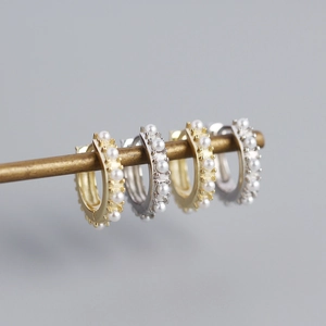 Close-up of gold and silver S925 sterling silver hoops with elegant pearl inlay