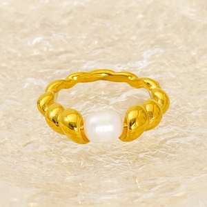 Elegant gold spiral ring with single white pearl centerpiece on textured glass background
