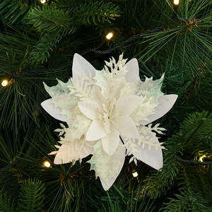 Sparkling white artificial Christmas flower ornament with sequins on green pine tree