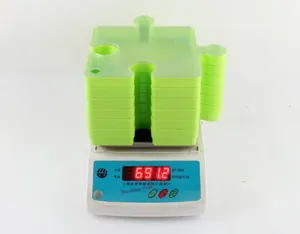 Detailed view of ten green stackable puzzle-shaped storage trays on a scale for weighing