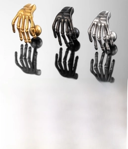 Detail view of gothic skull hand cartilage earrings in black silver and gold finish