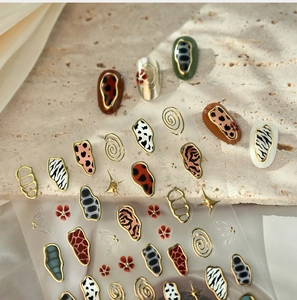Detail of animal print nail stickers with metallic gold edges and starry accents