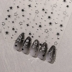 Gros plan de stickers à ongles étoiles argentées métalliques avec motifs 3D sur ongles gris
