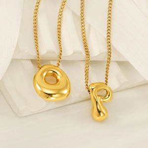 Polished gold bubble initial necklaces featuring letters O and P on minimalist pendants