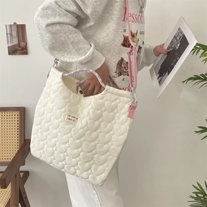 Détail du sac cabas matelassé à cœurs avec poignée tressée colorée et bandoulière