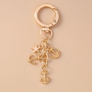 Golden alloy keychain with anchor and starfish charms on a metallic ring chain