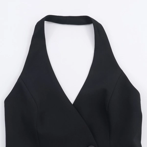 Detail of black halter vest showing deep V-neckline and double-breasted button design