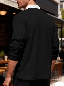 Detail of men's black long sleeve polo with white contrast collar on a model
