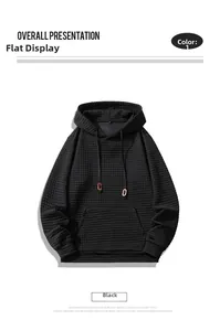 Close-up of black waffle knit hoodie showing textured fabric, drawstring hood and kangaroo pocket