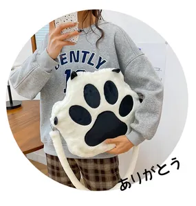 Detailed view of a white plush cat paw shoulder bag with black paw pad design details