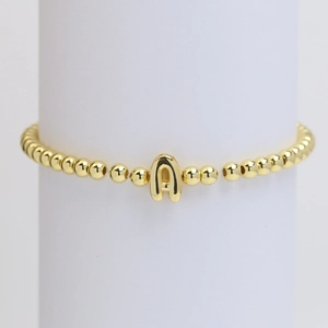 Polished 18k gold beaded elastic bracelet featuring a minimalist letter A balloon charm