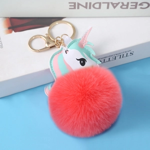 Detailed close-up of a pink unicorn PU leather keychain with a soft red faux fur pompom charm