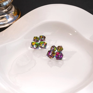 Close-up of geometric cube aurora crystal earrings showing colorful light refraction