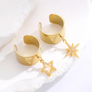 Vintage χρυσά σκουλαρίκια ear cuffs με αστέρια πάνω σε λευκή πέτρινη βάση