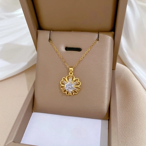 Elegant gold-tone hollow flower pendant necklace with diamonds on a white silk base