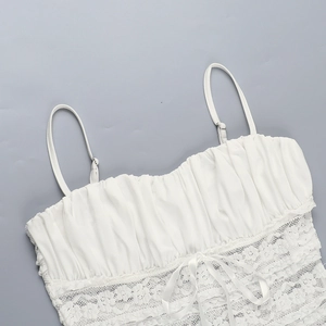 Close-up of white floral lace detail and ribbon bow on a sexy camisole top