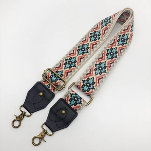 Close-up of ethnic geometric pattern strap with vintage bronze clips and leather ends