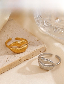 Detail of adjustable gold and silver lip rings with vertical texture on silk background
