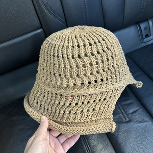 Detail of light brown hollow-out knit bucket hat showing intricate crochet texture