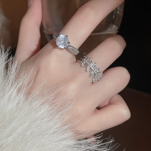 Close-up of zircon snowflake rotating ring and vine leaf diamond band on a finger