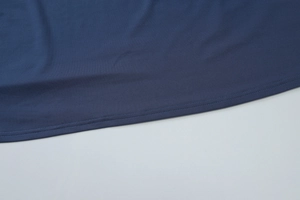 Detailaufnahme des blauen Kleidsaums mit präziser Doppelnadel-Nähtechnik auf Stoff