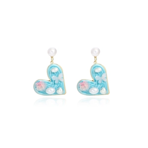 Detail of heart-shaped earrings featuring blue enamel with pearls and floral butterfly motifs