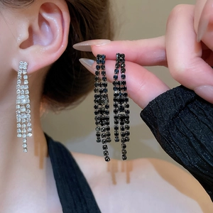 Détail de boucles d'oreilles longues à pampilles en argent et noir avec cristaux de zircon
