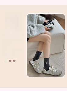 Détail de chaussettes gris foncé avec broderie mouton blanc et texture en coton fin