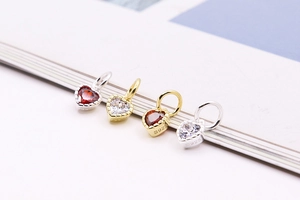 Close-up of S925 sterling silver heart pendants with red zircon and clear gemstones